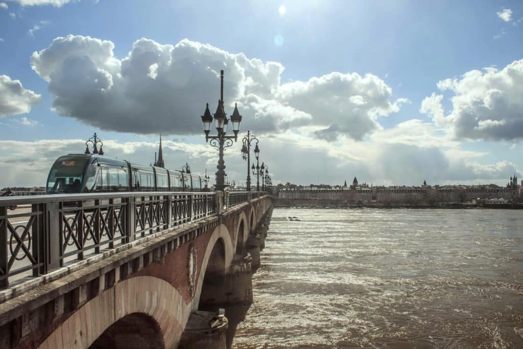 Accommodation in Bordeaux: a tram crossing the Pont de Pierre, linking the city neighbourhoods to the course locations