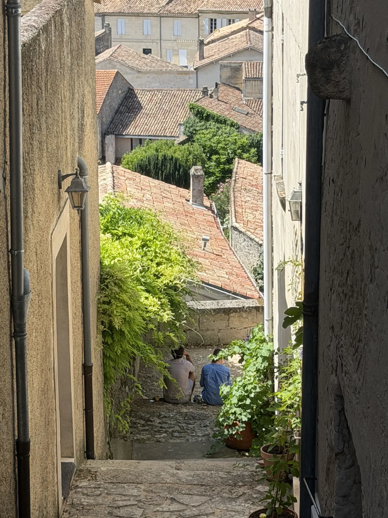 Visitors on a stepped medieval lane in Saint-Émilion, above the village rooftops